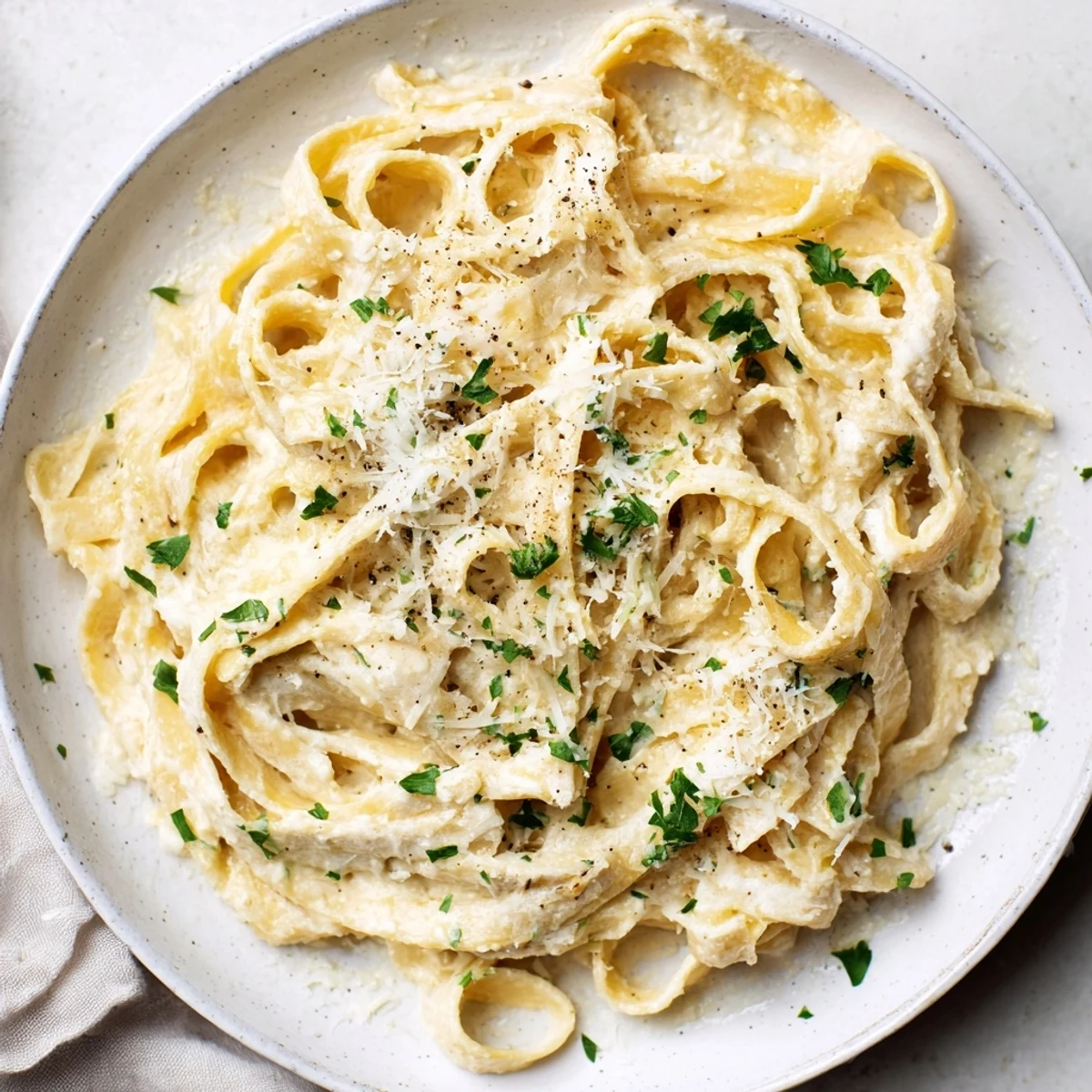 Fresh parsley garnishes the perfectly cooked 20-minute creamy Alfredo pasta, a simple Italian comfort food.