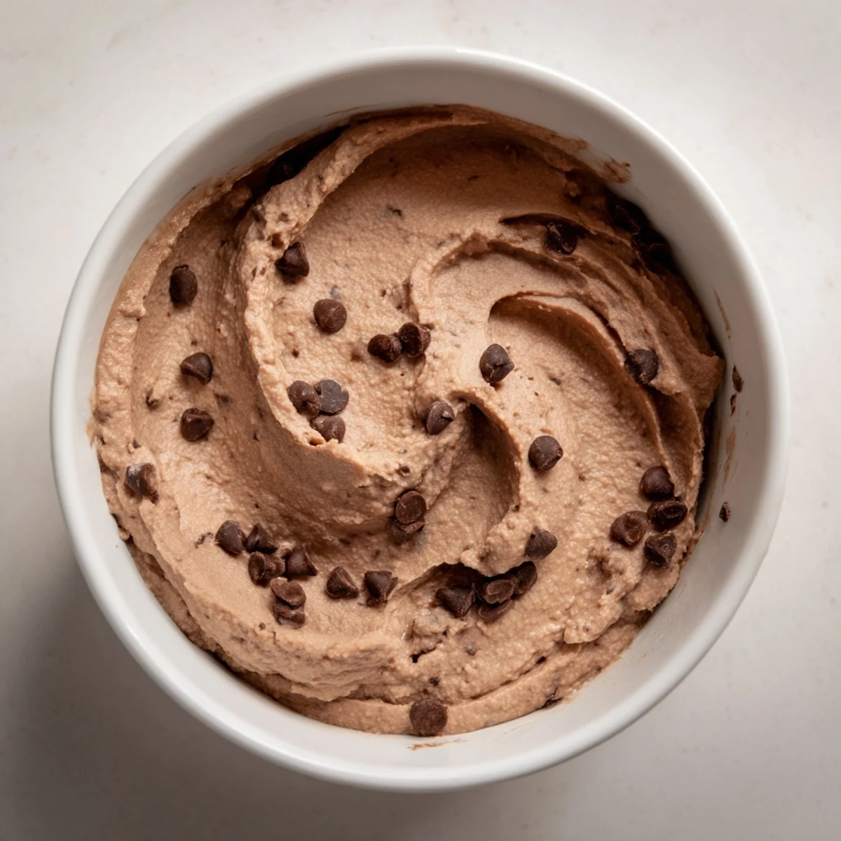 Smooth and creamy chocolate hummus, perfect for dipping apple slices, ready to savor.