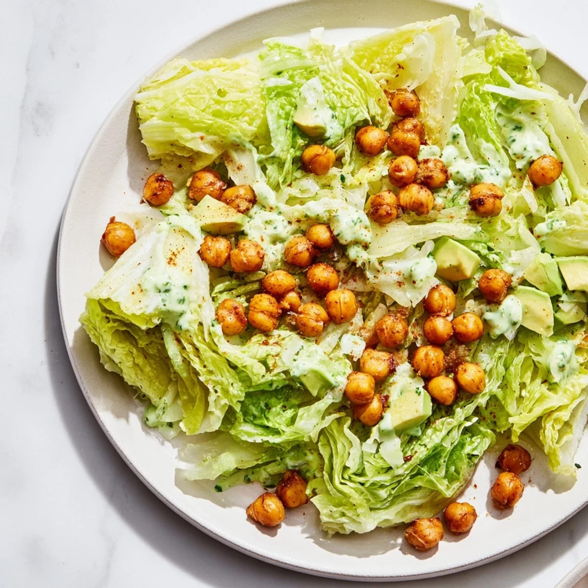 This close-up photo shows a serving of Green Goddess Salad, boasting a vibrant green hue with crunchy chickpeas.