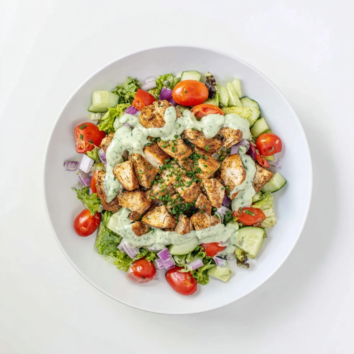 Juicy grilled chicken chunks tossed in creamy avocado ranch dressing over crisp mixed greens and diced vegetables.