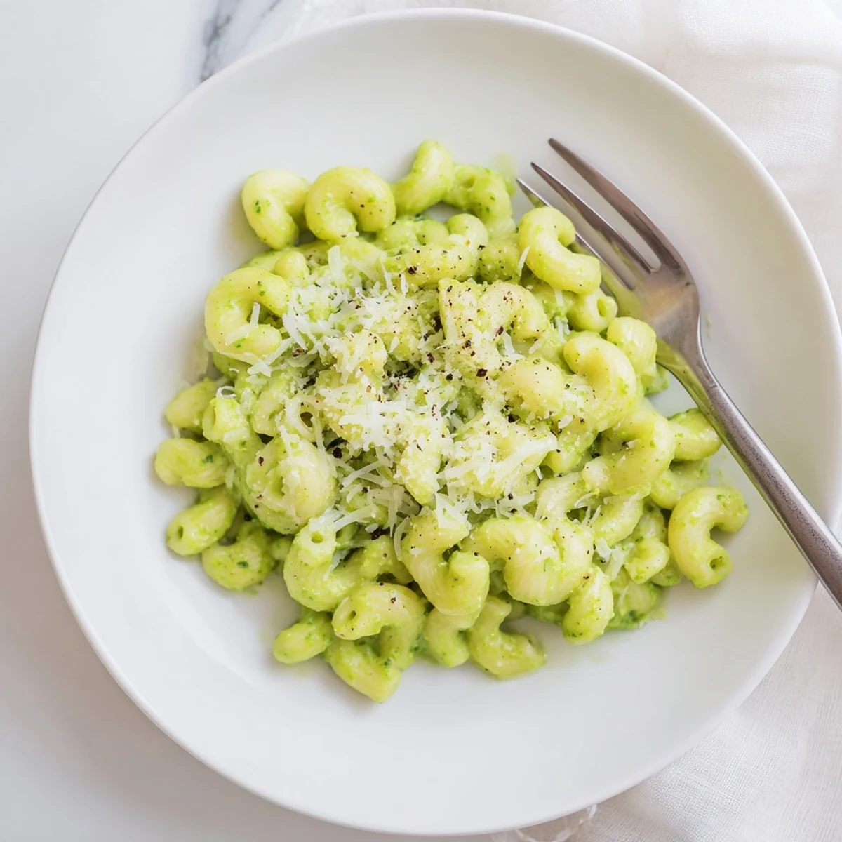 Creamy avocado pesto mac and cheese with tender pasta coated in a smooth, vibrant green sauce.  