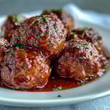 Golden meatballs coated in apricot preserves and soy sauce fill a slow cooker, ready to serve over fluffy white rice.  