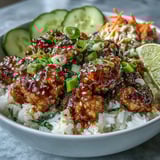 Warm Bang Bang Ground Turkey Rice Bowls topped with sesame seeds, scallions, cilantro, and lime wedges ready for serving.