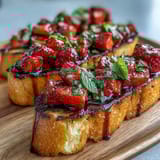 Fresh Strawberry Bruschetta with Balsamic and Mint - a vibrant summer appetizer of juicy strawberries, mint, and balsamic drizzle on golden toasted baguette slices.