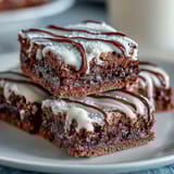 Baseball-themed brownie bites with white icing laces, perfect for game day desserts or sports party snacks.