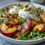 Vibrant summer salad: juicy grilled peaches, creamy burrata, and fresh basil.