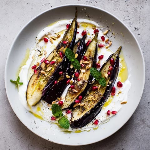 This photo shows beautifully roasted eggplant with yogurt sauce, a visually appealing vegetarian dish.