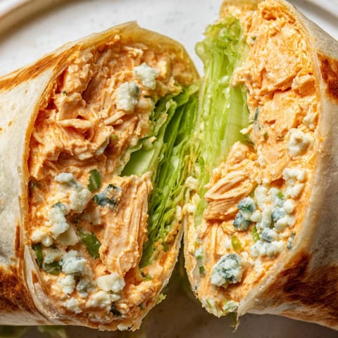 A close-up shot of a Buffalo Chicken Dip Wrap showcasing the creamy filling and fresh ingredients.
