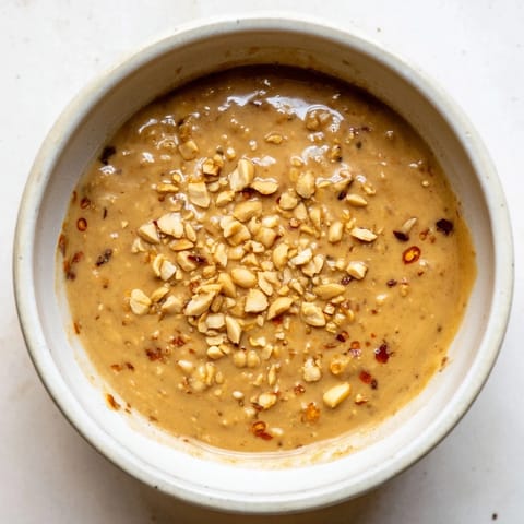 A bowl of fragrant Indonesian satay sauce, ready to be drizzled over skewered chicken or tofu.