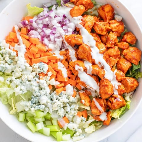 Crisp romaine and spicy buffalo chicken chunks are tossed with diced celery and creamy blue cheese crumbles in this vibrant chopped salad.