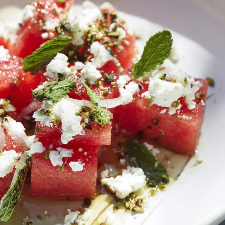Close-up of a flavorful Fresh Watermelon and Feta Salad, garnished with mint and a balsamic drizzle.