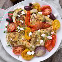Golden, roasted Easy Sheet Pan Greek Chicken alongside vibrant bell peppers and tomatoes, ready to enjoy.